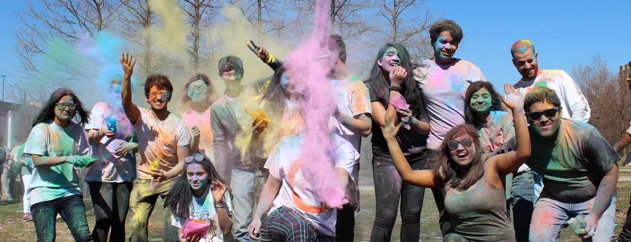 A group of students throws color during the Holi festival on UC's campus.